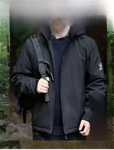 Detail of black windproof jacket with fleece lining and detachable hood in forest setting