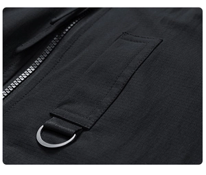 Detail view of black ripstop technical fabric with metal D-ring and zipper on jacket