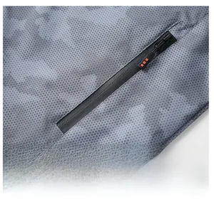 Detail view of invisible zipper pocket on grey camo jacket with honeycomb fabric texture