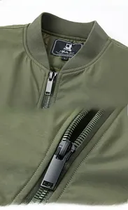 Detail of olive green bomber jacket featuring ribbed collar, metal zipper, and inner size label