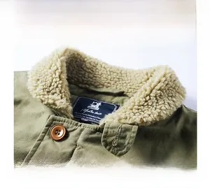 Gros plan sur la veste en velours vert olive avec doublure sherpa beige et col
