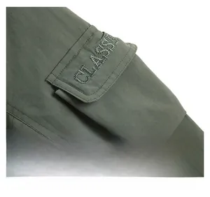 Detail der Armklappentasche mit klassischer Stickerei auf grüner Winterjacke