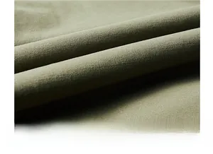 Détail macro du tissu en velours côtelé vert olive montrant la texture douce et le tissage