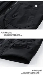 Detailed view of black jacket showing metal button pocket and ribbed hem texture