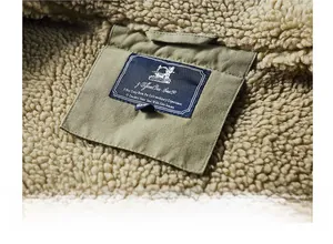 Détail du col d'une veste vert olive avec doublure sherpa et étiquette tissée