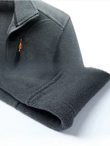 Detail of gray fleece jacket showing precision stitching on shoulders and hem