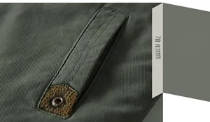Detail of slanted side pocket on army green cotton jacket with brown leather trim