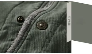 Detailed macro view of metal snap button with FASHION engraving on heavy twill jacket