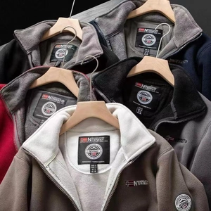 Detailed view of fleece jacket collars with zippers, logo embroidery and size labels