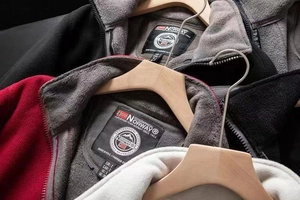 Detail of multi-color polar fleece jackets featuring high collar zippers and brand labels