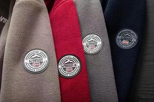 Close-up of Geographical Norway fleece jackets showing textured fabric and embroidered patches