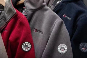 Detailed view of three warm polar fleece jackets featuring embroidered flags and badges