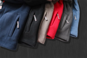 Detail of multi-color thermal fleece hoodies showing sleeve zipper pockets and ribbed cuffs