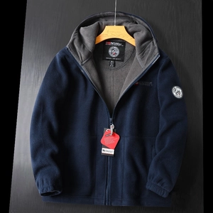 Detail of navy polar fleece jacket with warm grey lining and brand logo patches