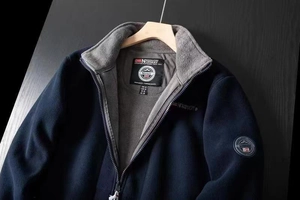 Detailed view of dark blue fleece jacket with full zipper and warm gray fleece lining