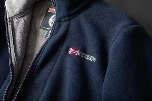 Detail of navy fleece jacket showing grey lining and Norway flag embroidery on the chest