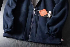 Detail view of navy blue fleece jacket with drawstring hem and elastic cuffs