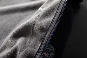 Macro shot of the warm grey fleece lining and zipper detail on the outdoor jacket