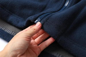 Close-up of navy blue thick fleece jacket showing warm texture and durable resin zipper
