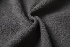 Macro shot of thick dark grey fleece fabric showing soft texture and thermal density
