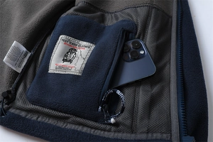 Macro shot of the inner zip pocket of a warm fleece jacket with a phone inside