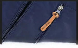 Detailed macro view of outdoor jacket zipper with embossed leather puller