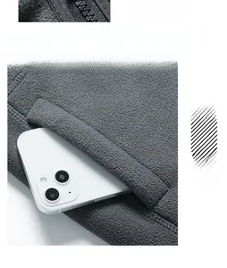 Detail of a deep gray fleece jacket featuring a deep side pocket with a mobile phone inside