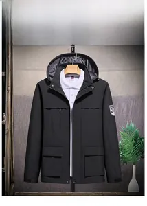Detail view of men's waterproof black outdoor jacket with multi-pockets and hood