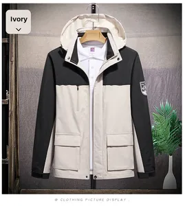 Detail of hooded ivory and black waterproof jacket with large flap pockets and Velcro cuffs