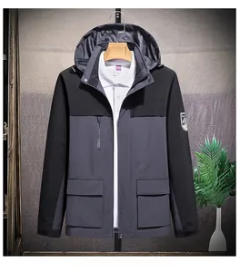 Close-up of gray and black waterproof jacket with hooded design and decorative sleeve badge