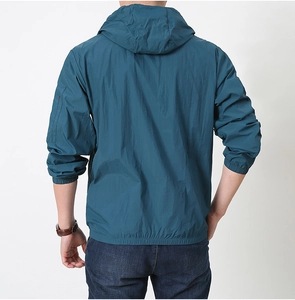 Detail view of peacock blue sun protection jacket with hood and functional arm zipper pocket