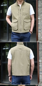 Detail of khaki outdoor vest showing multiple utility pockets and zip closure