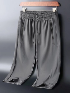 Macro detail of men's dark grey quick-dry joggers with elastic drawstring waist and zippers