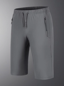 Detail of grey quick-dry pants featuring elastic waist with drawstring and zip pockets