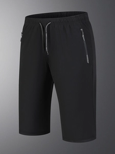 Detailed view of lightweight black sports shorts with drawstring waist and zipper pockets
