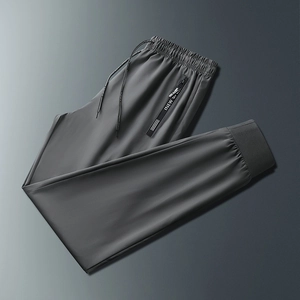 Detail of dark gray joggers with elastic waistband, drawstring and zip pockets
