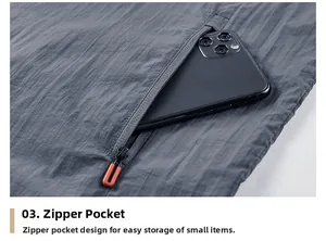 Detail view of gray sun protection jacket showing zipper pocket with orange pull cord