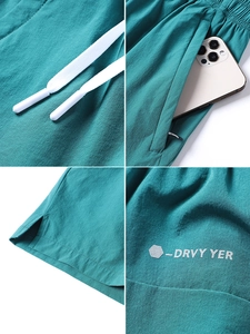 Details tealgrüner schnelltrocknender Shorts mit Taschen, Kordelzug und reflektierendem Logo
