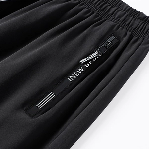 Detail of men's ice silk trousers featuring side zipper pocket and decorative letter tape