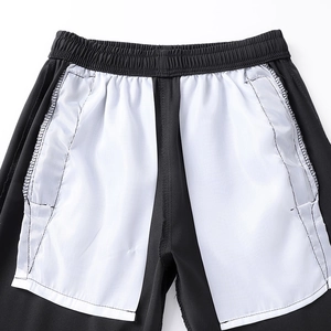Detail of elastic waistband and white pocket lining on black ice silk trousers