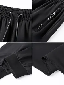 Detail of men's ice silk joggers featuring elastic drawstring waist and zipper pockets