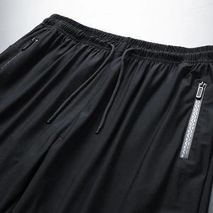 Detail of men's quick-dry pants featuring elastic drawstring waist and zipper pockets