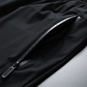 Detail of men's quick-dry sports pants with zipper pocket and reflective trim