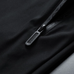 Macro view of waterproof zipper detail and breathable black knit fabric on men's pants