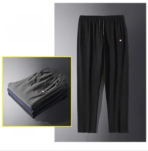 Dettaglio della vita con coulisse e nastro tricolore sui pantaloni sportivi da uomo