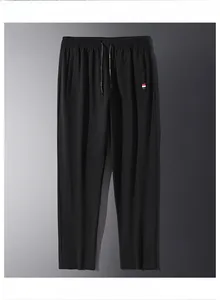 Dettaglio dei pantaloni sportivi neri con vita elastica a coulisse ed etichetta tricolore