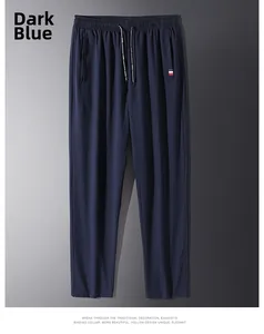 Dettaglio della tasca laterale dei pantaloni blu navy con etichetta a bandiera tricolore