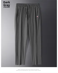 Dettaglio dei pantaloni sportivi grigio scuro con coulisse e nastro tricolore sulla tasca