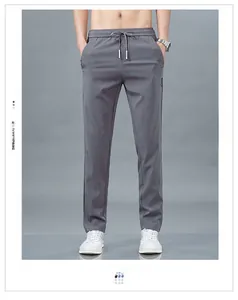 Détail de la taille élastique avec cordon et embouts métalliques sur pantalon gris