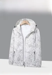 Détail de la veste coupe-vent blanche camouflage avec imprimé feuilles et poignets élastiques